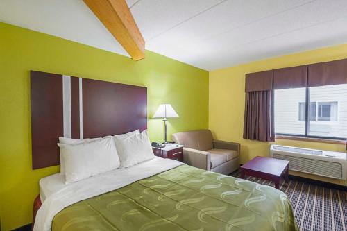 ein Hotelzimmer mit einem Bett und einem Stuhl in der Unterkunft Quality Inn & Suites Harrington in Harrington
