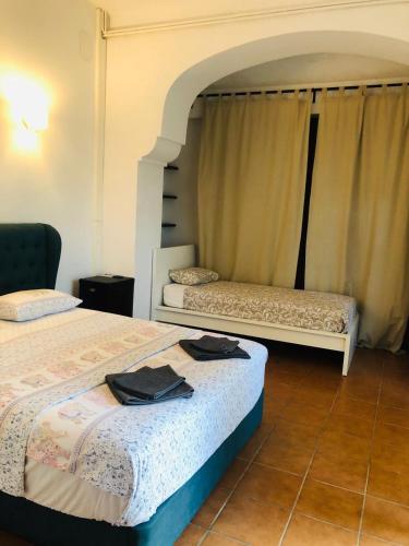 a bedroom with two beds and a window at Casa les Pomeretes in El Figaró