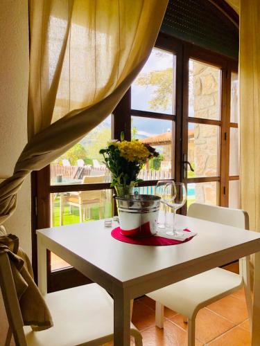 a table with a vase of flowers and a window at Casa les Pomeretes in El Figaró