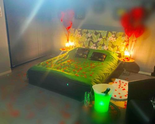 a bedroom with a green bed and two tables with candles at VIP LOUNGE Appartement avec Jacuzzi et jardin in Andenne