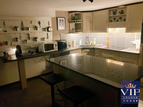 a kitchen with a counter top and a microwave at VIP LOUNGE Appartement avec Jacuzzi et jardin in Andenne