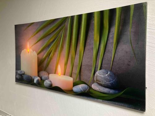 a painting of candles and rocks on a wall at VIP LOUNGE Appartement avec Jacuzzi et jardin in Andenne