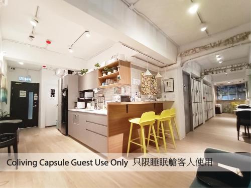 een keuken met gele krukken in een kamer bij i-Hostel (Cameron Road) in Hong Kong