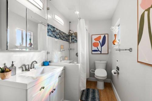 a white bathroom with a sink and a toilet at Cozy Heights House Patio and Backyard Sleeps 9 in Houston