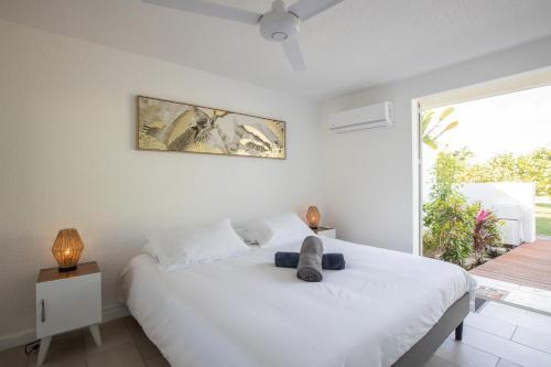 een slaapkamer met een wit bed en een groot raam bij Baie Nettle Beach Villa 2080 in Saint Martin