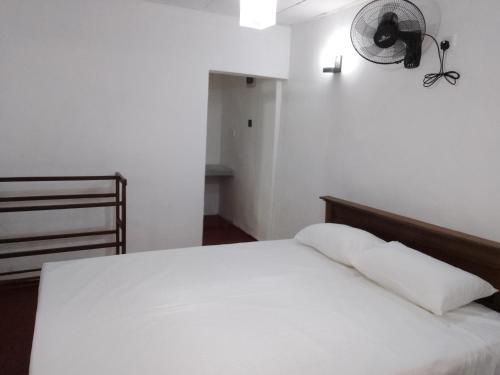 ミリッサにあるRainbow mountain villaのベッドルーム(白いベッド1台、ファン付)