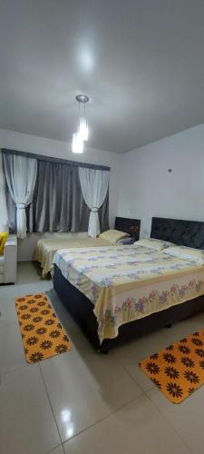 a bedroom with two beds and two rugs at Hospede Mar Bombinhas in Bombinhas