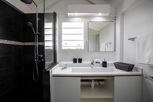 a white bathroom with a sink and a shower at Modern Beach Villa 1150 in Saint Martin