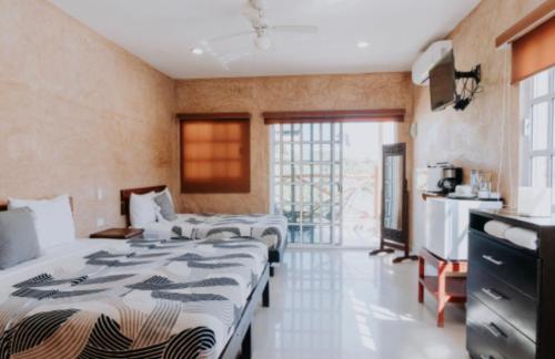 a hotel room with two beds and a kitchen at habitaciones Mi Viejo Chit in Holbox Island
