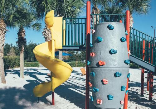a playground with a yellow slide and a climbing structure at Amazing Private Villa @ Orang Lake Resort in Orlando