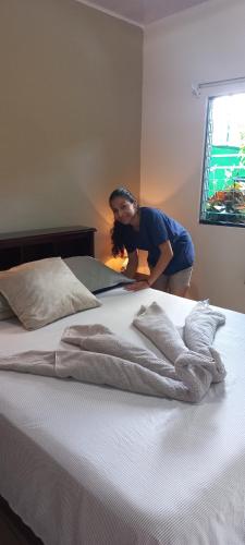 una mujer está de pie junto a una cama en Hotel Trianon en San José