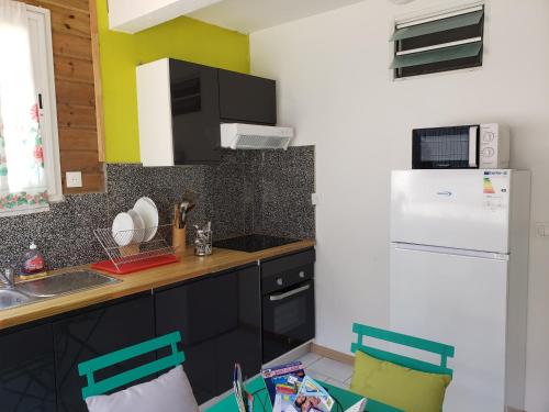a kitchen with a sink and a white refrigerator at ptit coin hibiscus2 in Pointe-Noire