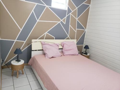 a bedroom with a white bed with pink pillows at ptit coin hibiscus2 in Pointe-Noire