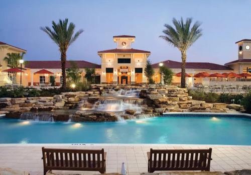 a swimming pool with a waterfall in front of a house at Amazing Private Villa @ Orang Lake Resort in Orlando