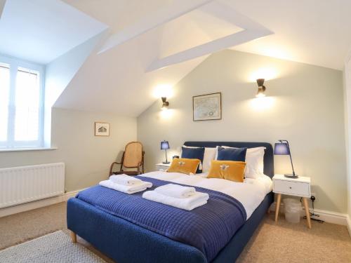 - une chambre avec un grand lit bleu et des serviettes dans l'établissement Poppy Cottage, à Southwold