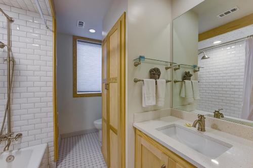 a bathroom with a sink and a mirror and a tub at Vacation Rental Home in Downtown Vicksburg! in Vicksburg