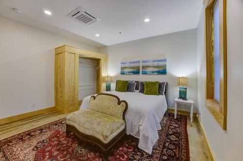 a bedroom with a bed and a chair at Historic Upscale Loft in Downtown Vicksburg! in Vicksburg