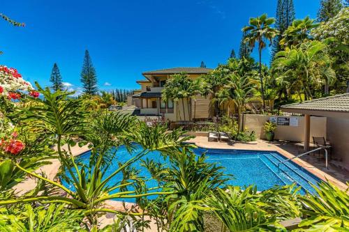 una piscina di fronte a una casa con palme di Kapalua Golf Villas by Coldwell Banker Island Vacations a Kahana