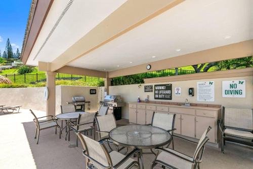 un patio con tavoli e sedie e un bancone antidumping di Kapalua Golf Villas by Coldwell Banker Island Vacations a Kahana