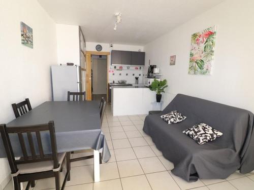 une cuisine et une salle à manger avec une table et des chaises dans l'établissement Charmant Studio Cabine avec Jardin - Proche Plage et Commerces - Parking Sécurisé - FR-1-307-118, au Grau-du-Roi