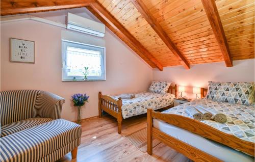 um quarto com 2 camas, uma cadeira e uma janela em Stunning Home In Susobreg With Outdoor Swimming Pool, Wifi And 3 Bedrooms 
