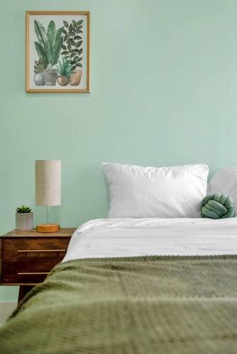 a bedroom with a bed and a table with a lamp at Green N' Groovy in the Heart of East Rock Near DT, Yale in New Haven