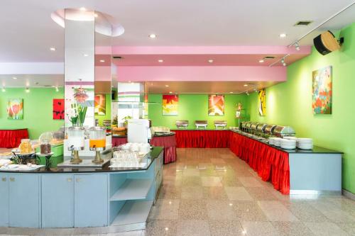 a restaurant with bright green walls and red counters at Bella Villa Metro in Pattaya North