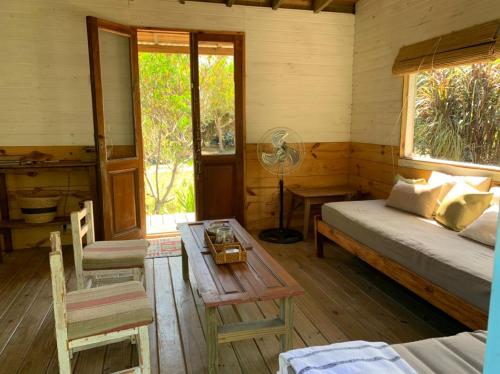 1 dormitorio con cama, mesa y ventana en La Marencoche - Casa de Madera en Punta Rubia, en La Paloma