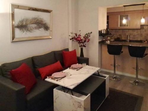 uma sala de estar com um sofá e uma mesa com almofadas vermelhas em Smart Design Home - Buenos Aires em Buenos Aires
