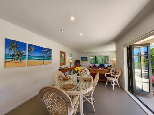 a dining room with a table and chairs at Hahei Garden Sanctuary in Hahei