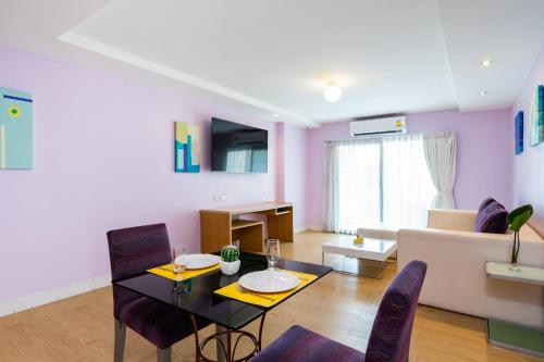 a living room with a table and chairs and a couch at Best Bella Pattaya in Pattaya North