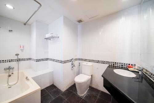 a white bathroom with a sink and a toilet and a tub at Best Bella Pattaya in Pattaya North