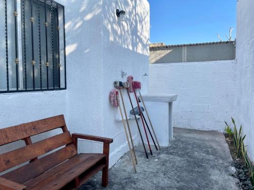 a bench next to a wall with skis and ski poles at Casa el conquistador/ExcelenteUbicación/2Hab/Wifi in Mérida