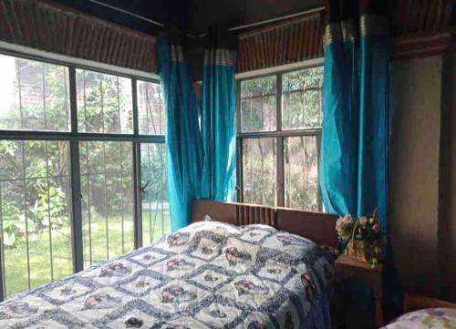 - une chambre avec un lit doté de rideaux bleus et de fenêtres dans l'établissement CASA VACACIONAL, à Cocoyoc