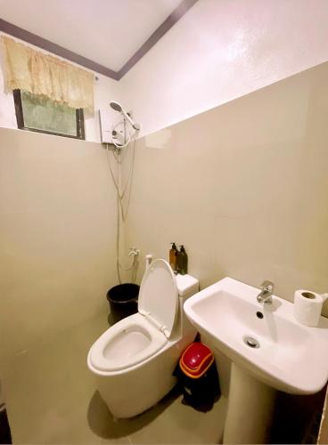 a bathroom with a toilet and a sink at Flo Island Home in General Luna