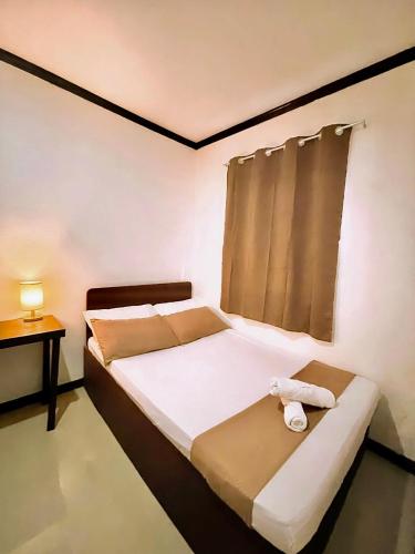 a bedroom with a bed with a towel on it at Flo Island Home in General Luna