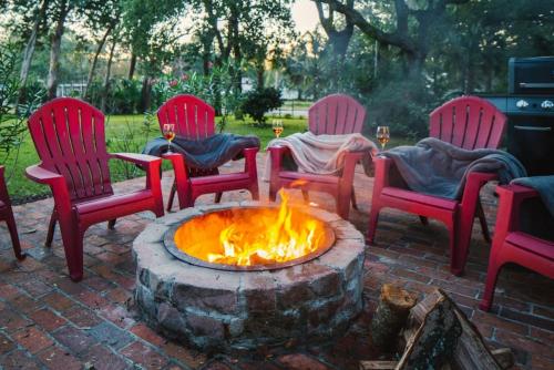 a group of red chairs around a fire pit at 5BR House King Beds Steps To Beach Ideal for Families With Dogs in Myrtle Beach