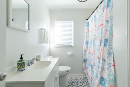 a bathroom with a sink and a toilet and a shower curtain at 5BR House King Beds Steps To Beach Ideal for Families With Dogs in Myrtle Beach