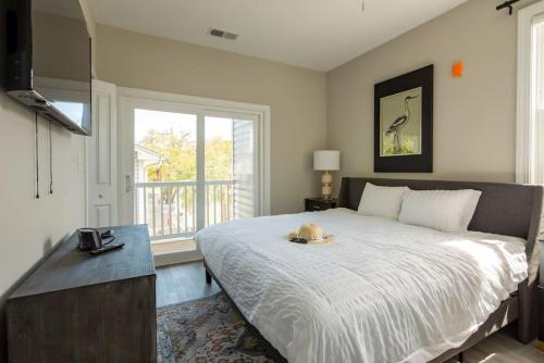 a bedroom with a large bed and a window at Modern 4BR Ground Level King Beds Steps 2 Beach C in Myrtle Beach