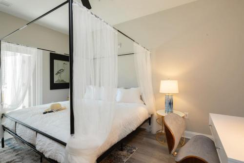 a bedroom with a canopy bed with a mirror at Modern 4BR Ground Level King Beds Steps 2 Beach C in Myrtle Beach