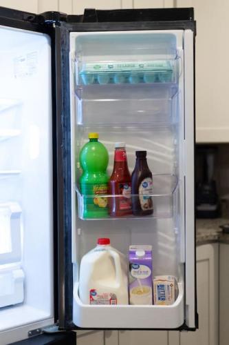 an open refrigerator filled with milk and juice at Modern 4BR Ground Level King Beds Steps 2 Beach C in Myrtle Beach