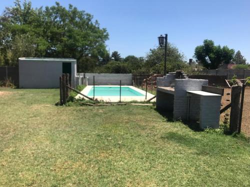 ein Pool in einem Garten mit einem Zaun in der Unterkunft Casa rural familiar con pileta in Arrecifes