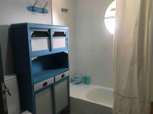 einen blauen Schrank im Bad mit Badewanne in der Unterkunft Casa rural familiar con pileta in Arrecifes