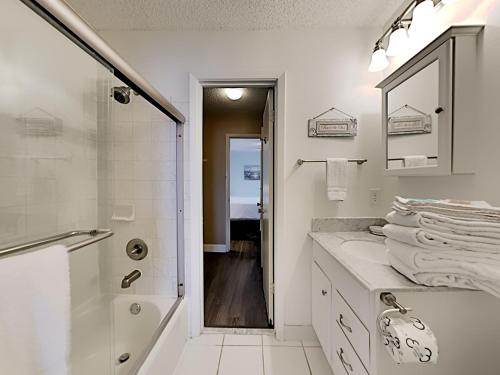 een witte badkamer met een douche en een wastafel bij Villas On The Gulf h6 in Pensacola Beach