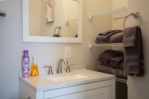a bathroom with a sink and a mirror and towels at Lovely 4BR King Beds Steps To Beach And Pier G in Myrtle Beach