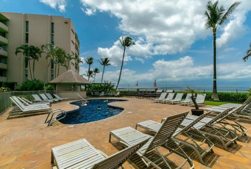 un grupo de tumbonas y una piscina con el océano en Island Sands by Coldwell Banker Island Vacations, en Maalaea