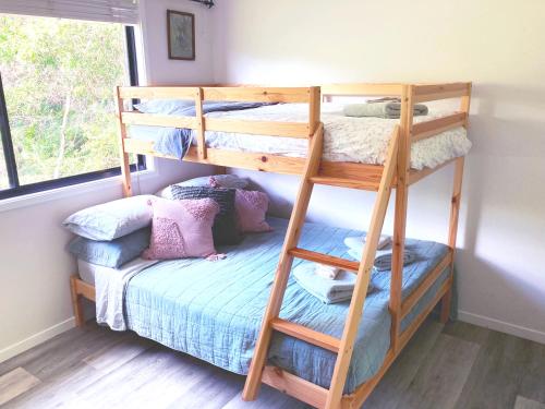 Quiet Private Nimbin Townhouse في نيمبين: غرفة بسرير بطابقين وسرير