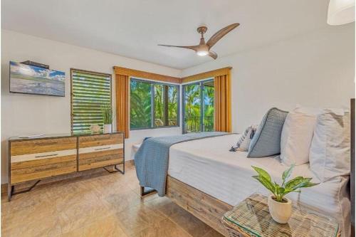 a bedroom with a bed with a dresser and windows at WAILEA ELUA, #1509 condo in Wailea