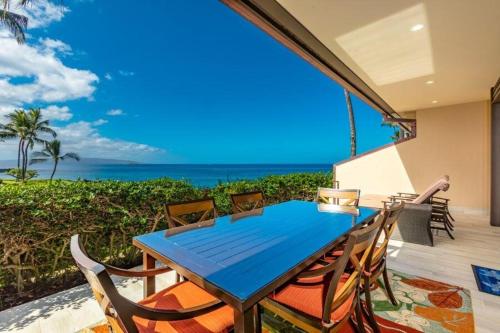 a blue table and chairs on a balcony with the ocean at MAKENA SURF, #G-101 condo in Wailea
