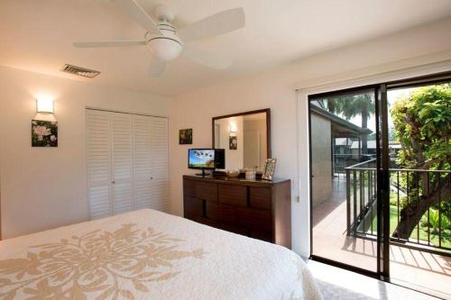 a bedroom with a bed and a sliding glass door at Wailea Elua, #0908 condo in Wailea